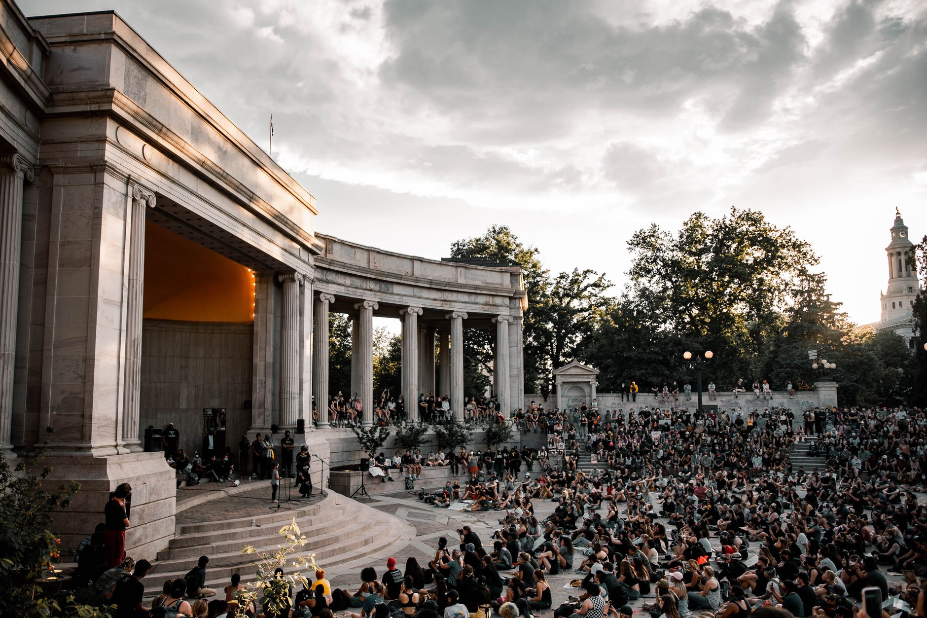 A large crowd gathers at the Greek Theatre in Denver during sunset for a public event. — Coronavirus disease 2019